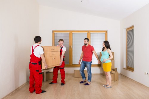 Professional movers handling furniture and packing for a residential move in To
