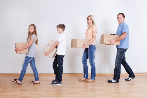 Team of movers organizing a home move with wrapped furniture and boxes